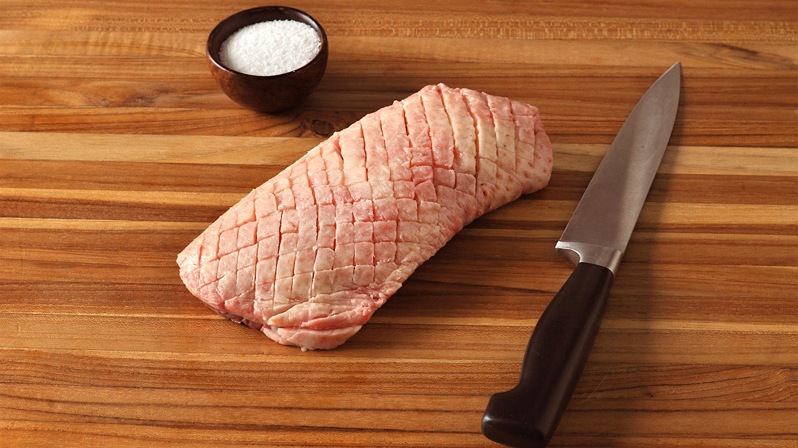 Uncooked duck breast with the fat on top scored into small diamonds